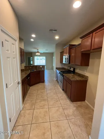 a kitchen with stainless steel appliances granite countertop a stove a microwave and a refrigerator