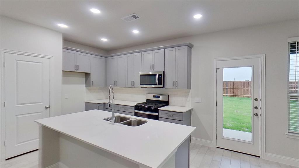 415 Magellan Road Seagoville, TX 75159 - Photo 3 of 14 a kitchen with a sink a stove and cabinets