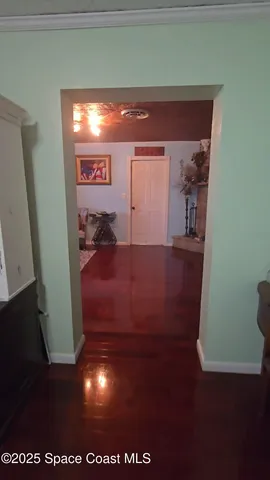 a view of a livingroom with wooden floor and a painting on the wall