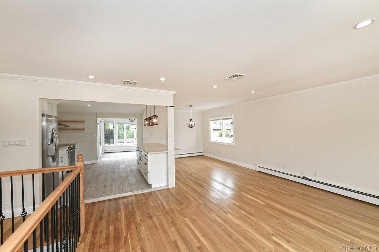 107 Beverly Road Massapequa, NY 11758 - Photo 5 of 41 a view of a hallway with wooden floor and staircase