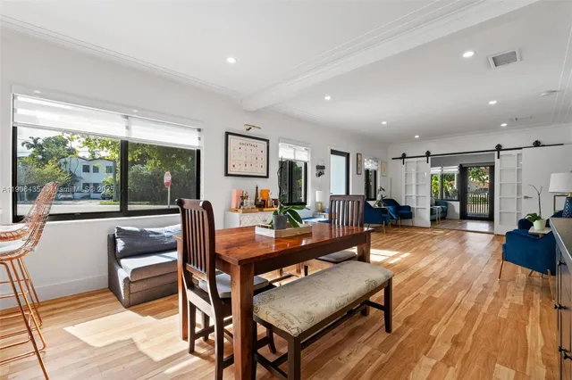 a kitchen with stainless steel appliances granite countertop a refrigerator a stove a sink dishwasher and white cabinets with wooden floor