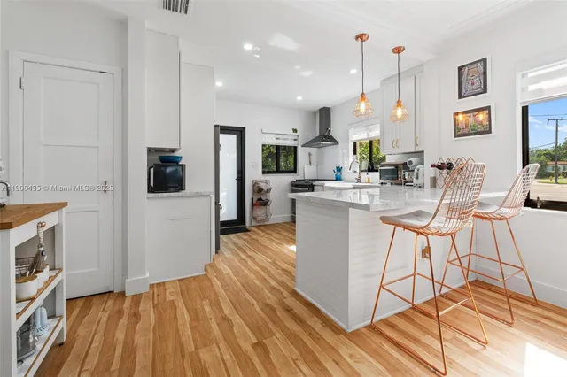 a kitchen with stainless steel appliances granite countertop a sink a stove and a wooden floors