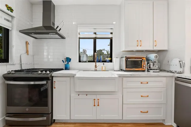 a kitchen with a refrigerator stove and white cabinets