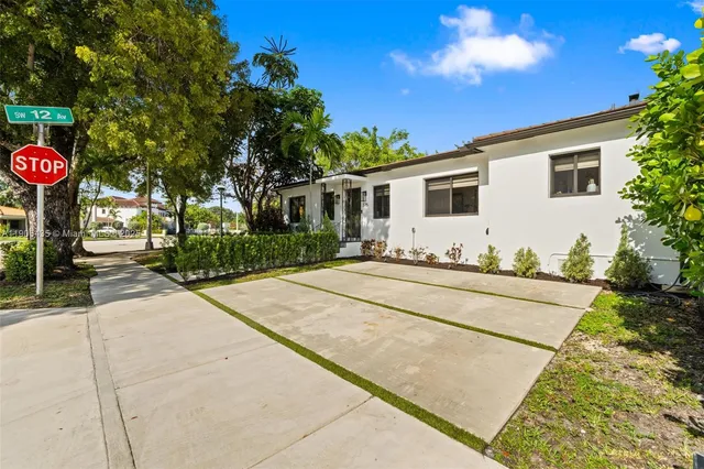a front view of a house with yard and dining space