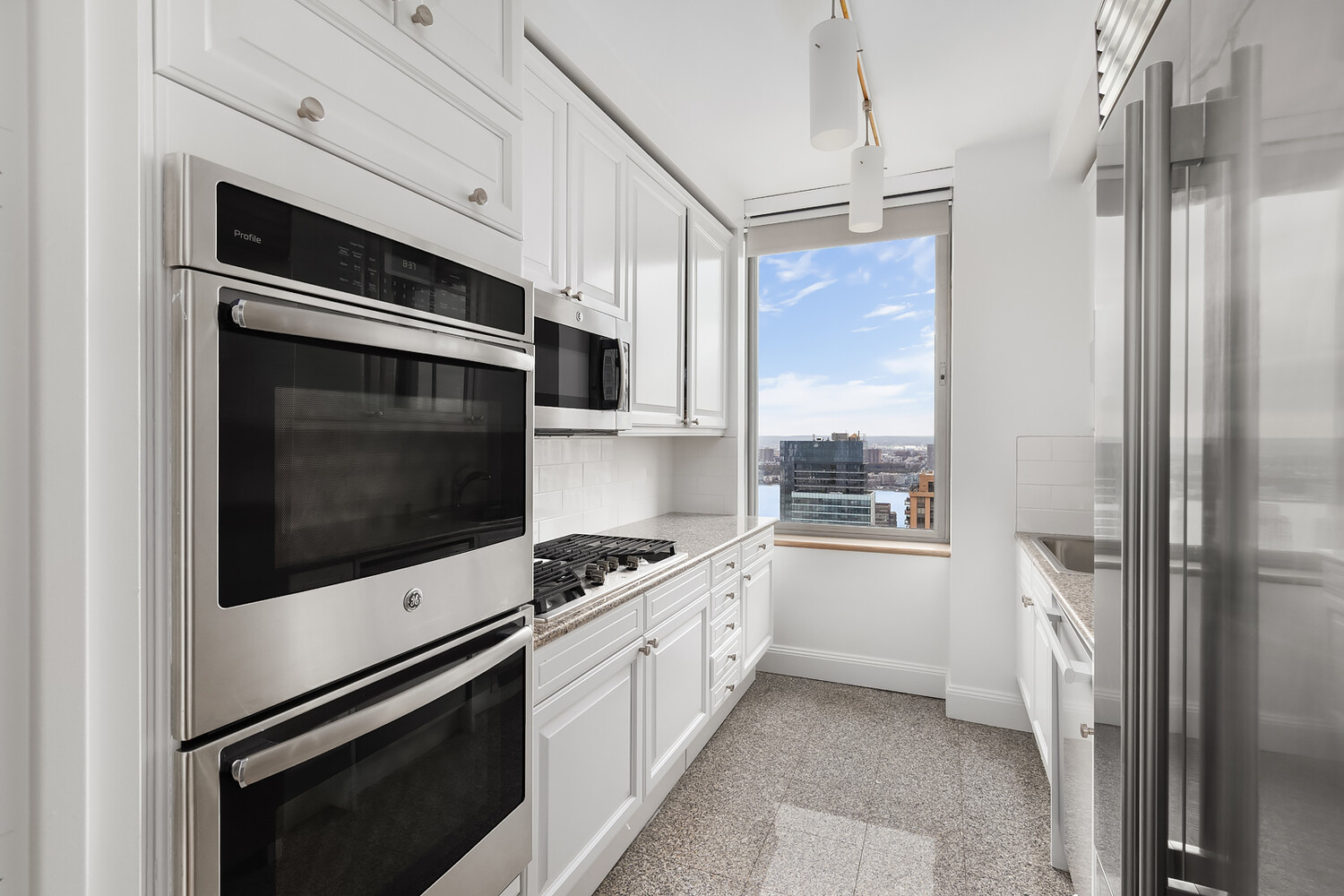 101 West 67th Street, Unit 52E Manhattan, NY 10023 - Photo 17 of 21 a kitchen with stainless steel appliances a stove a microwave and a refrigerator