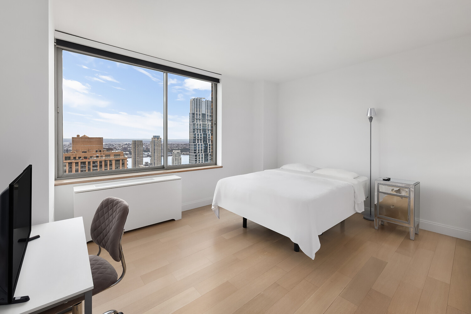 101 West 67th Street, Unit 52E Manhattan, NY 10023 - Photo 18 of 21 a bedroom with a bed chair and a large window