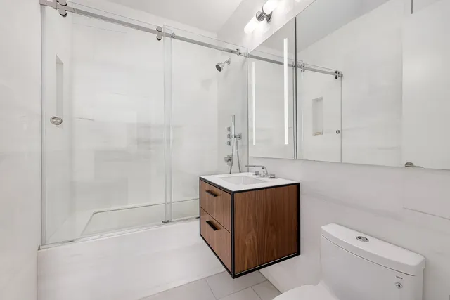 a bathroom with a sink a toilet and mirror