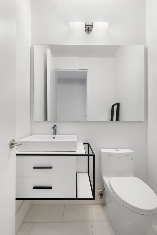 101 West 67th Street, Unit 52E Manhattan, NY 10023 - Photo 20 of 21 a bathroom with a sink a toilet and mirror