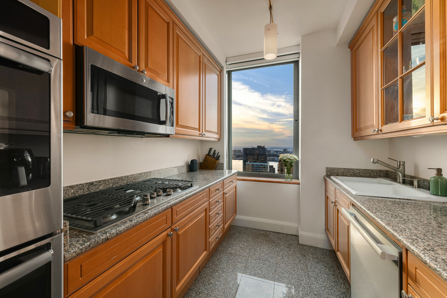 101 West 67th Street, Unit 52E Manhattan, NY 10023 - Photo 8 of 21 a kitchen with stainless steel appliances granite countertop a stove a sink and a microwave