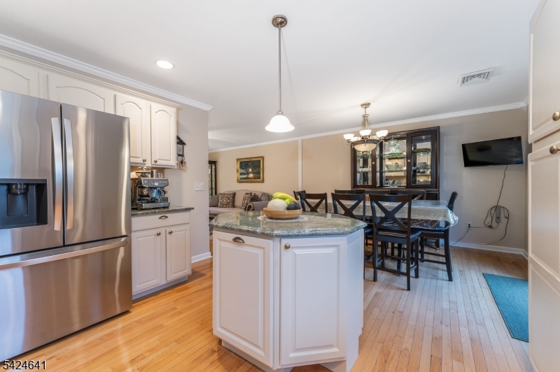 21 Marble Street Washington, NJ 07882 - Photo 5 of 21 a kitchen with stainless steel appliances granite countertop a refrigerator a stove a sink dishwasher and a dining table with wooden floor