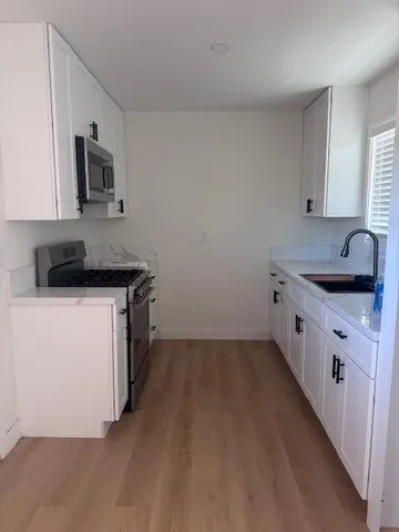 a kitchen with a sink and a stove top oven