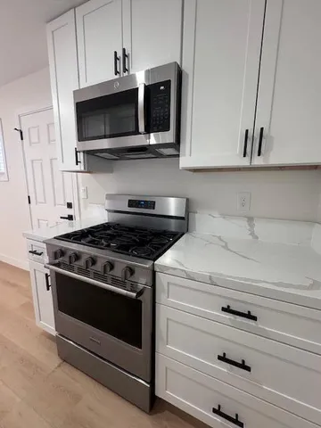 a stove top oven sitting inside of a kitchen