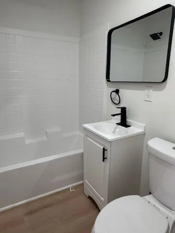 a bathroom with a toilet sink and mirror