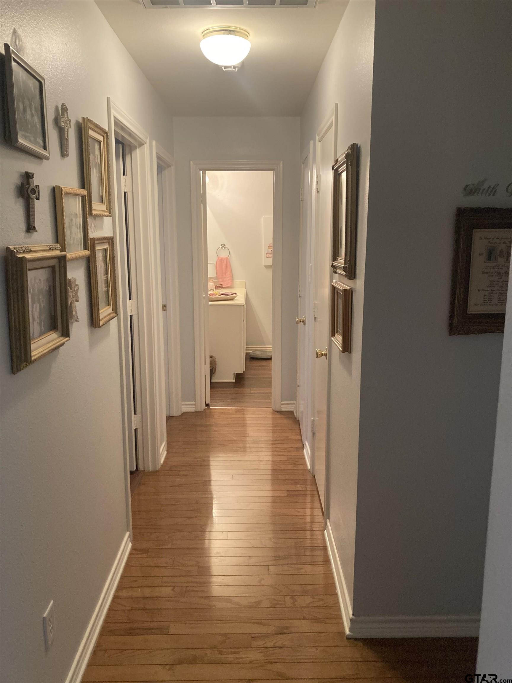 1521 Rice Road, Unit Q103 Tyler, TX 75703 - Photo 18 of 40 a view of a hallway with wooden floor and staircase