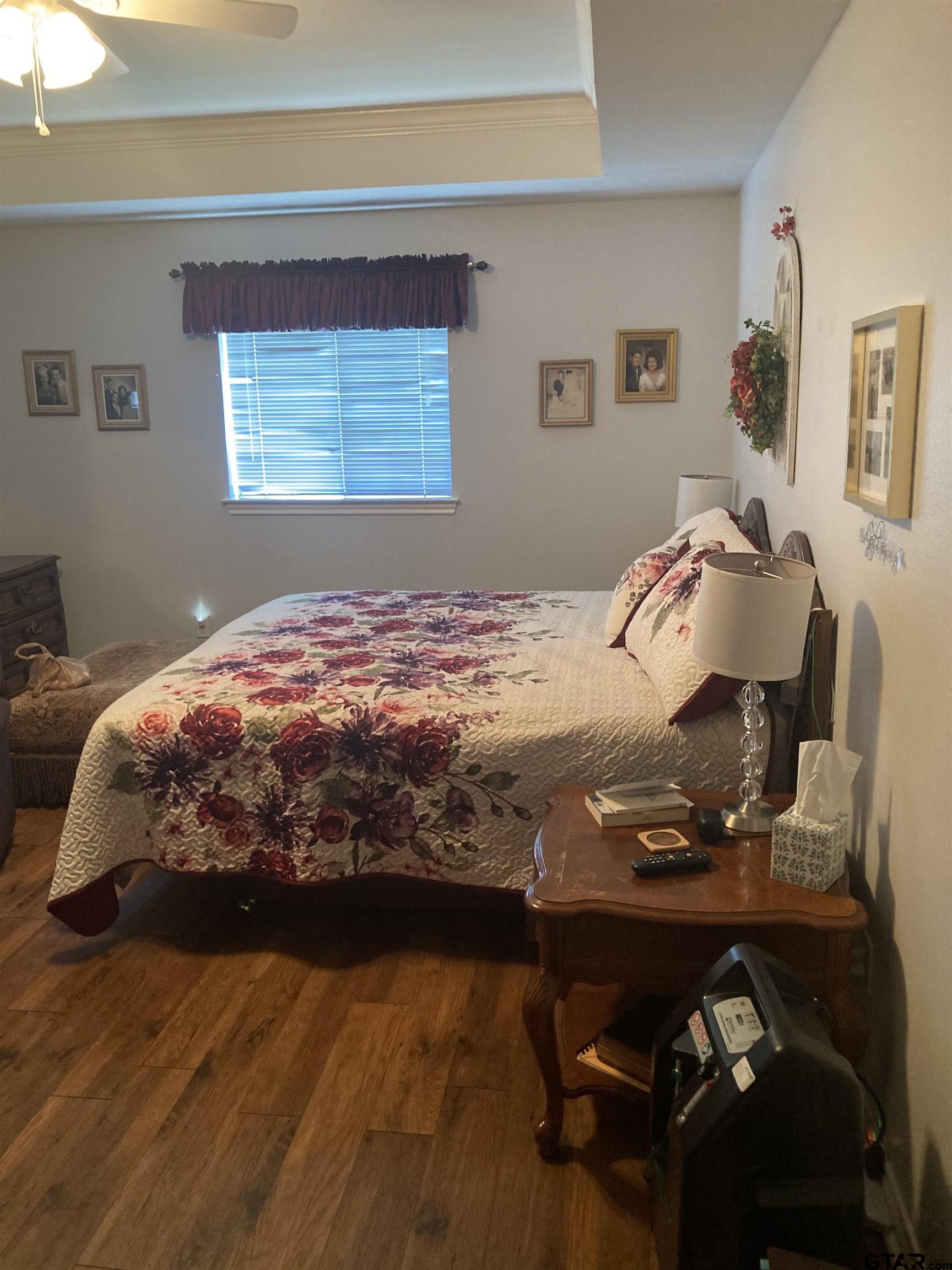 1521 Rice Road, Unit Q103 Tyler, TX 75703 - Photo 19 of 40 a bedroom with a bed and wooden floor