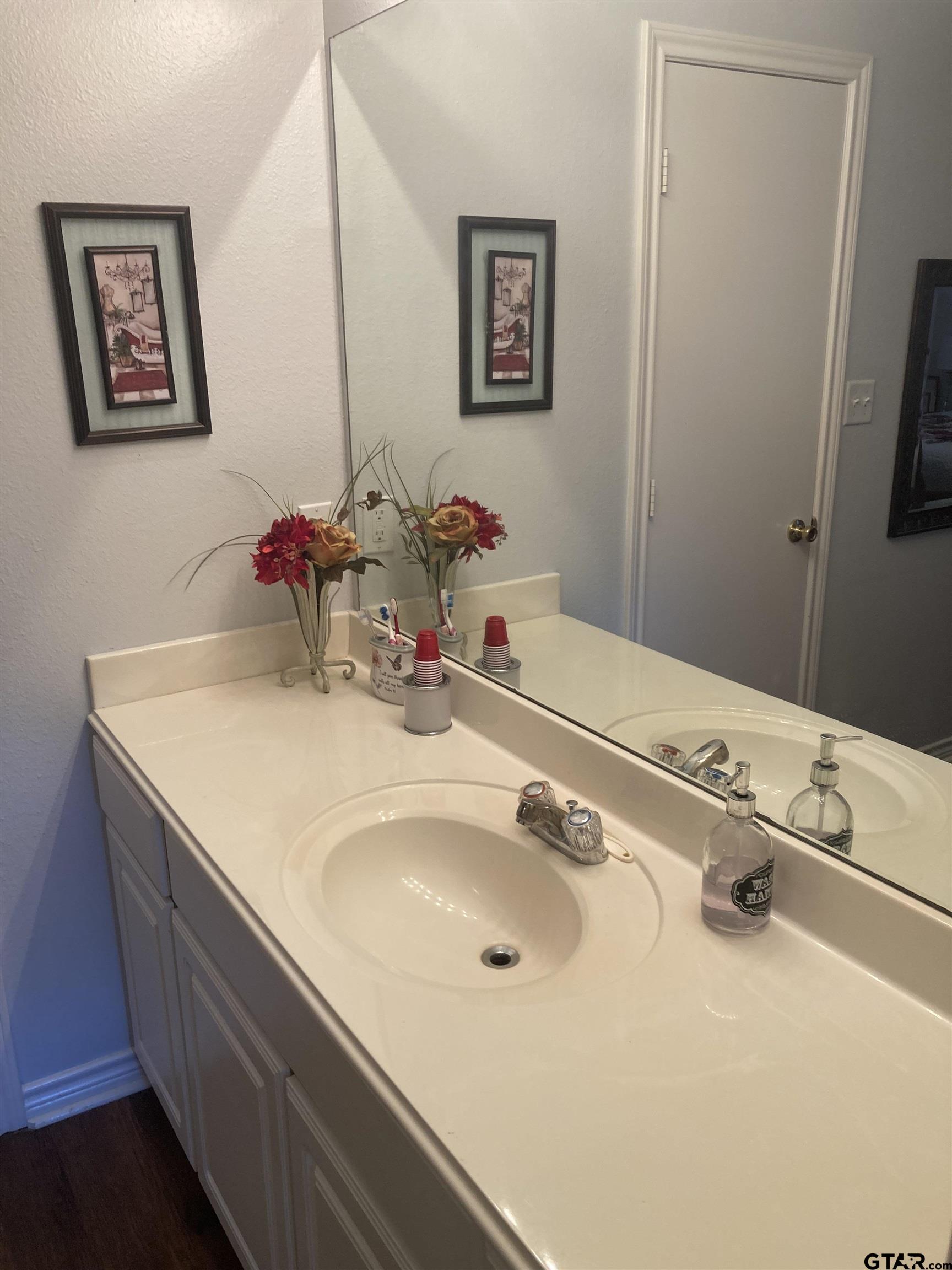 1521 Rice Road, Unit Q103 Tyler, TX 75703 - Photo 27 of 40 a bathroom with a sink and a mirror