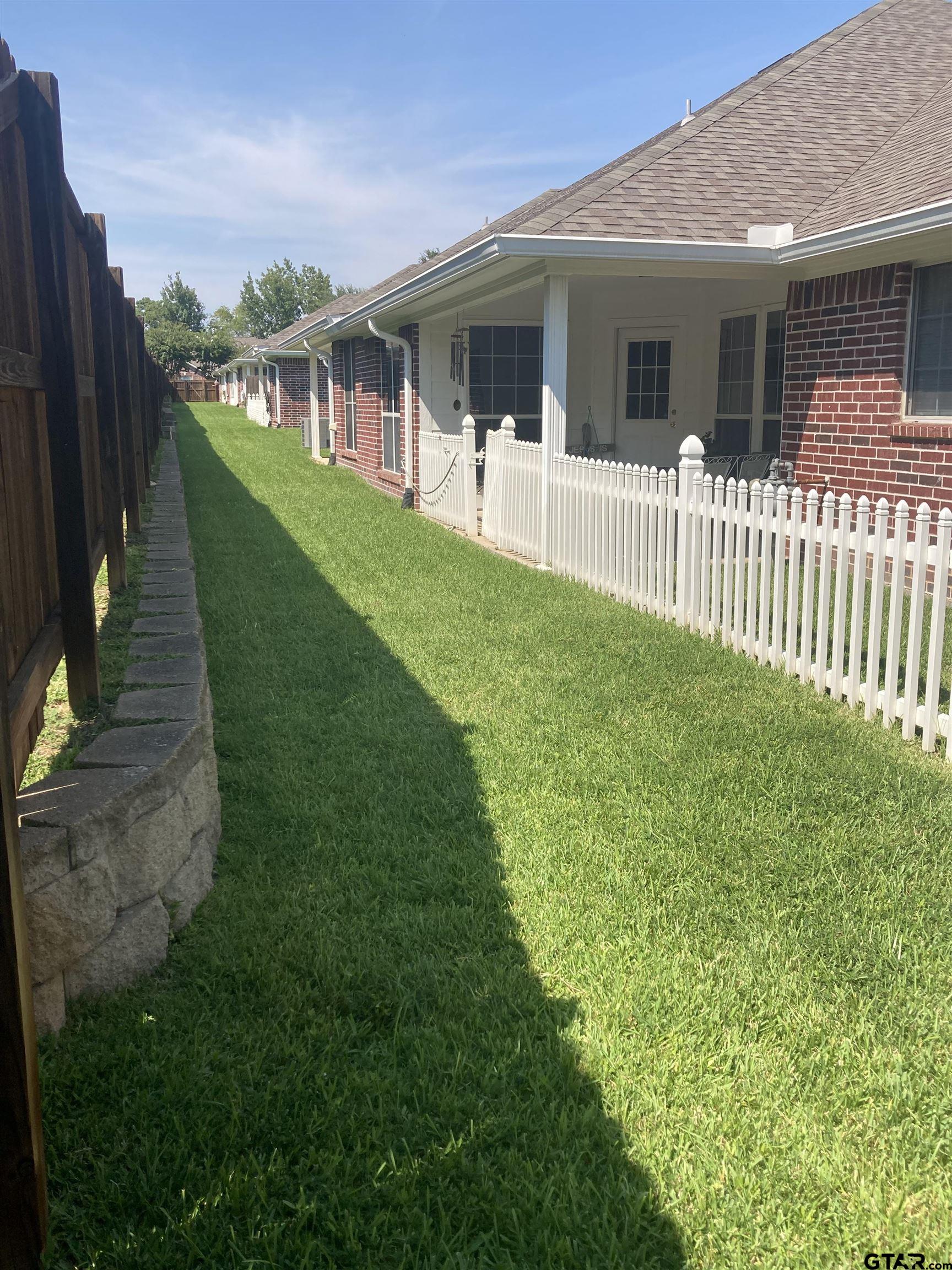 1521 Rice Road, Unit Q103 Tyler, TX 75703 - Photo 38 of 40 a view of a house with a yard and porch