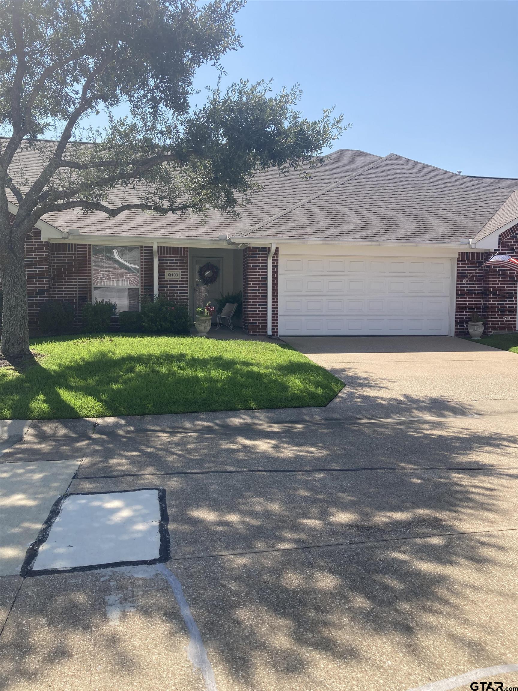 1521 Rice Road, Unit Q103 Tyler, TX 75703 - Photo 40 of 40 a front view of a house with a yard and a garage