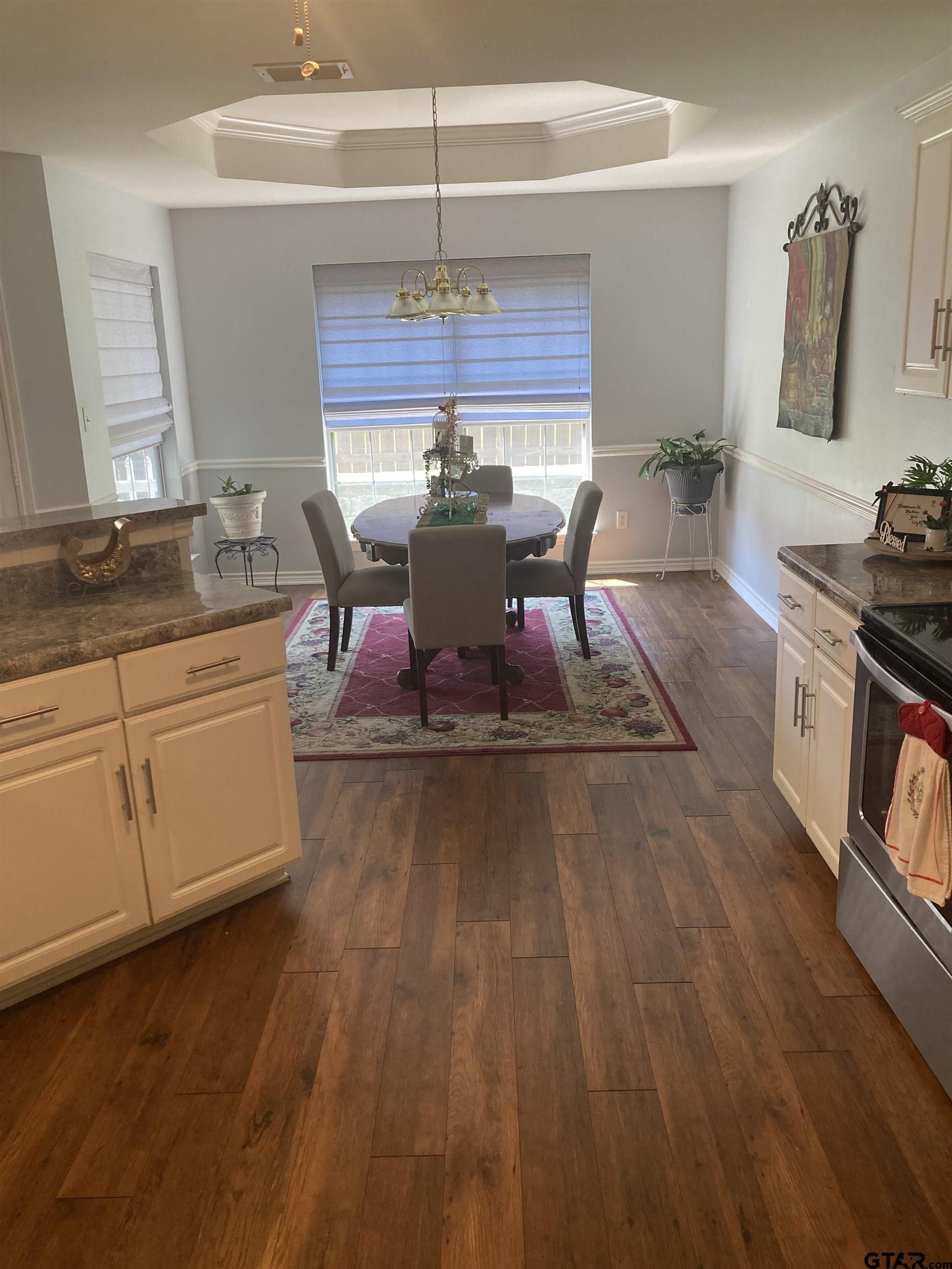 1521 Rice Road, Unit Q103 Tyler, TX 75703 - Photo 6 of 40 a living room with kitchen island granite countertop wooden floor and stainless steel appliances