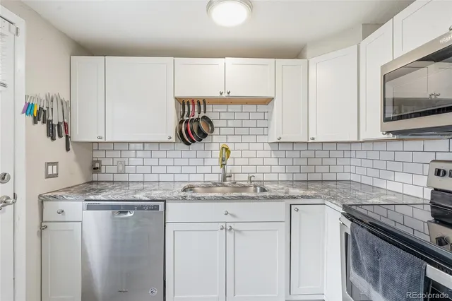 a kitchen with stainless steel appliances granite countertop a sink stove and cabinets