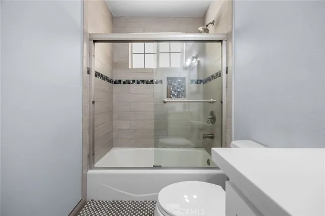 a bathroom with a shower a toilet and bathtub