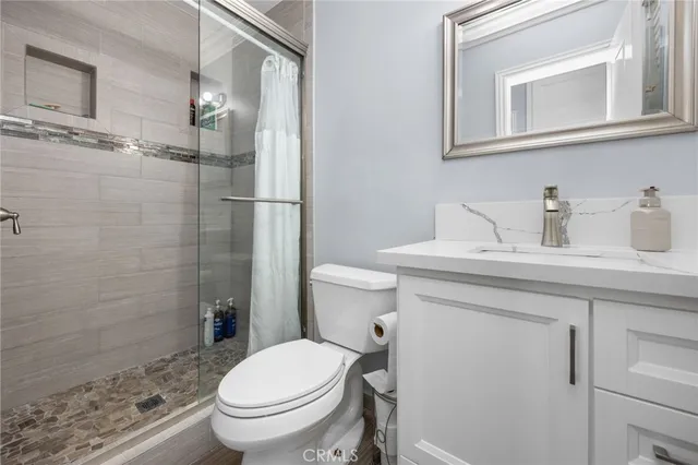 a bathroom with a granite countertop toilet sink and a mirror