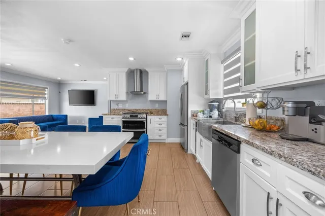 a kitchen with stainless steel appliances granite countertop a sink dishwasher stove refrigerator and cabinets with wooden floor