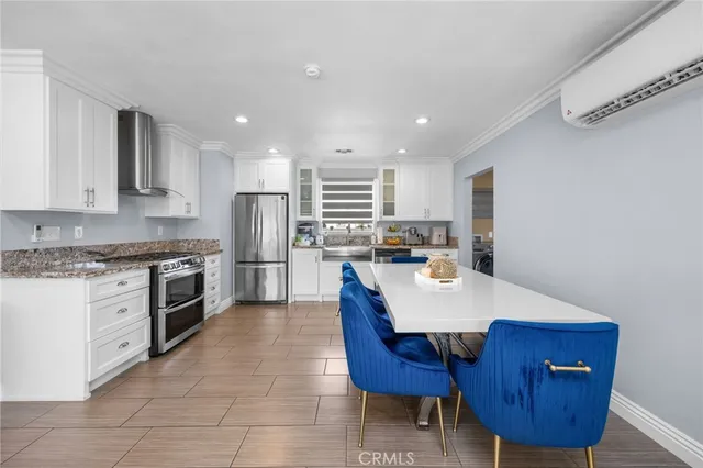 a kitchen with a refrigerator a stove a sink and chairs