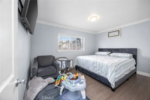 a bedroom with a bed a couch and a flat screen tv