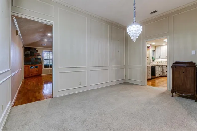 an empty room with chandelier fan and windows