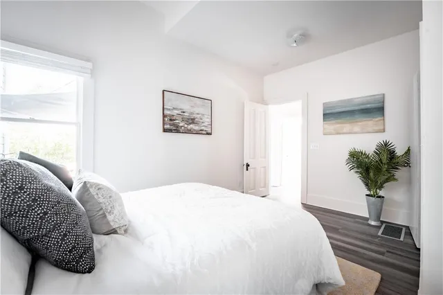 a bedroom with a large bed and a potted plant