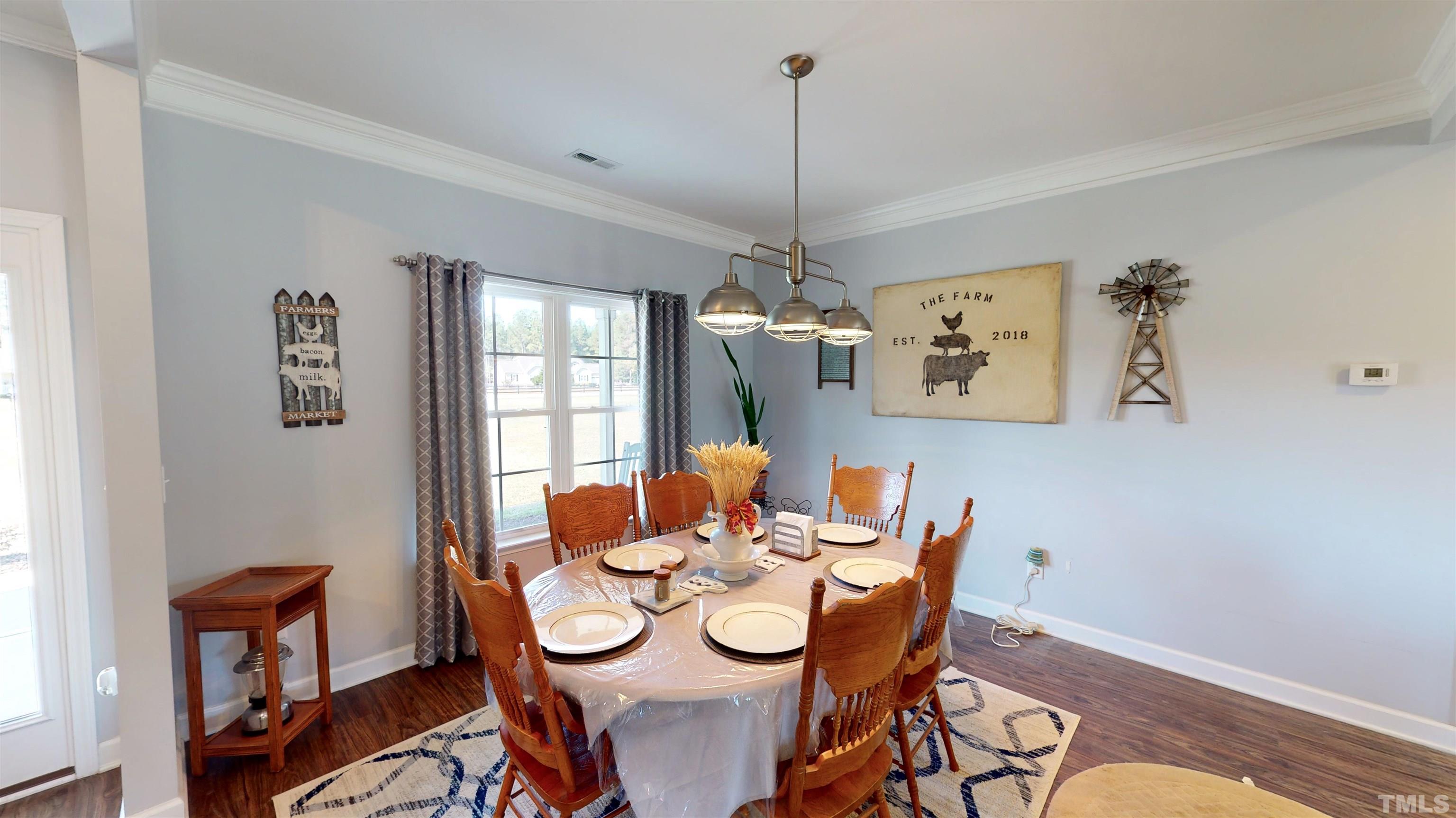 11250 Old Beulah Road Kenly, NC 27542 - Photo 13 of 66 a dining room with furniture a chandelier and wooden floor