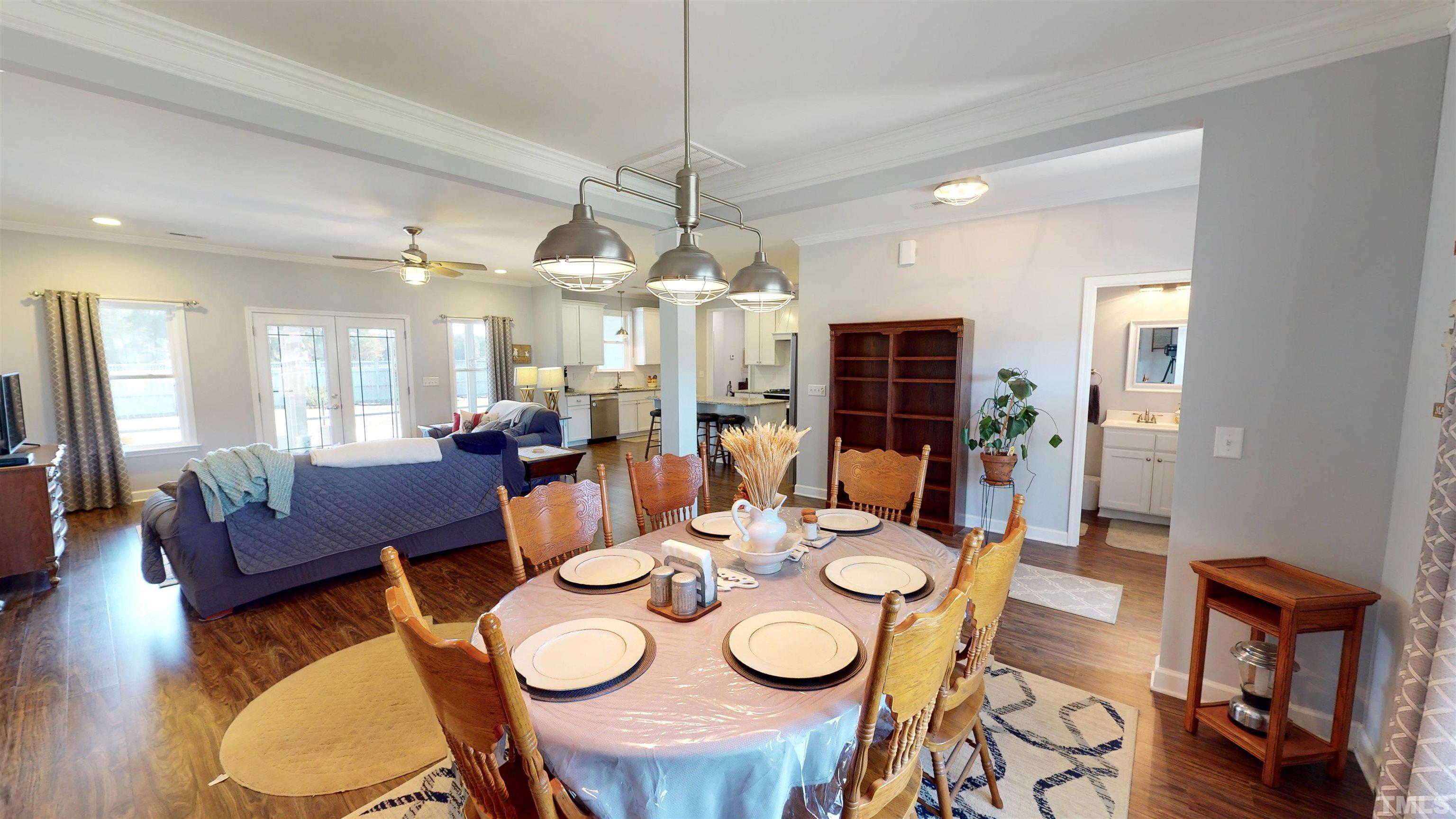 11250 Old Beulah Road Kenly, NC 27542 - Photo 14 of 66 a view of a dining room with furniture a chandelier and wooden floor