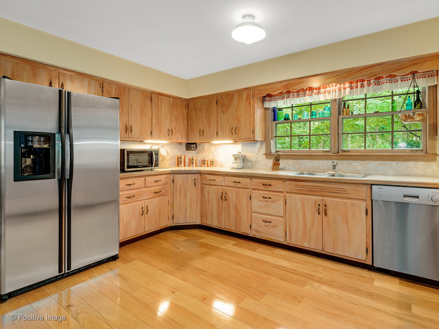 S206 Summit Drive Winfield, IL 60190 - Photo 11 of 34 a kitchen with stainless steel appliances granite countertop a sink a stove a refrigerator with grey cabinets and wooden floor