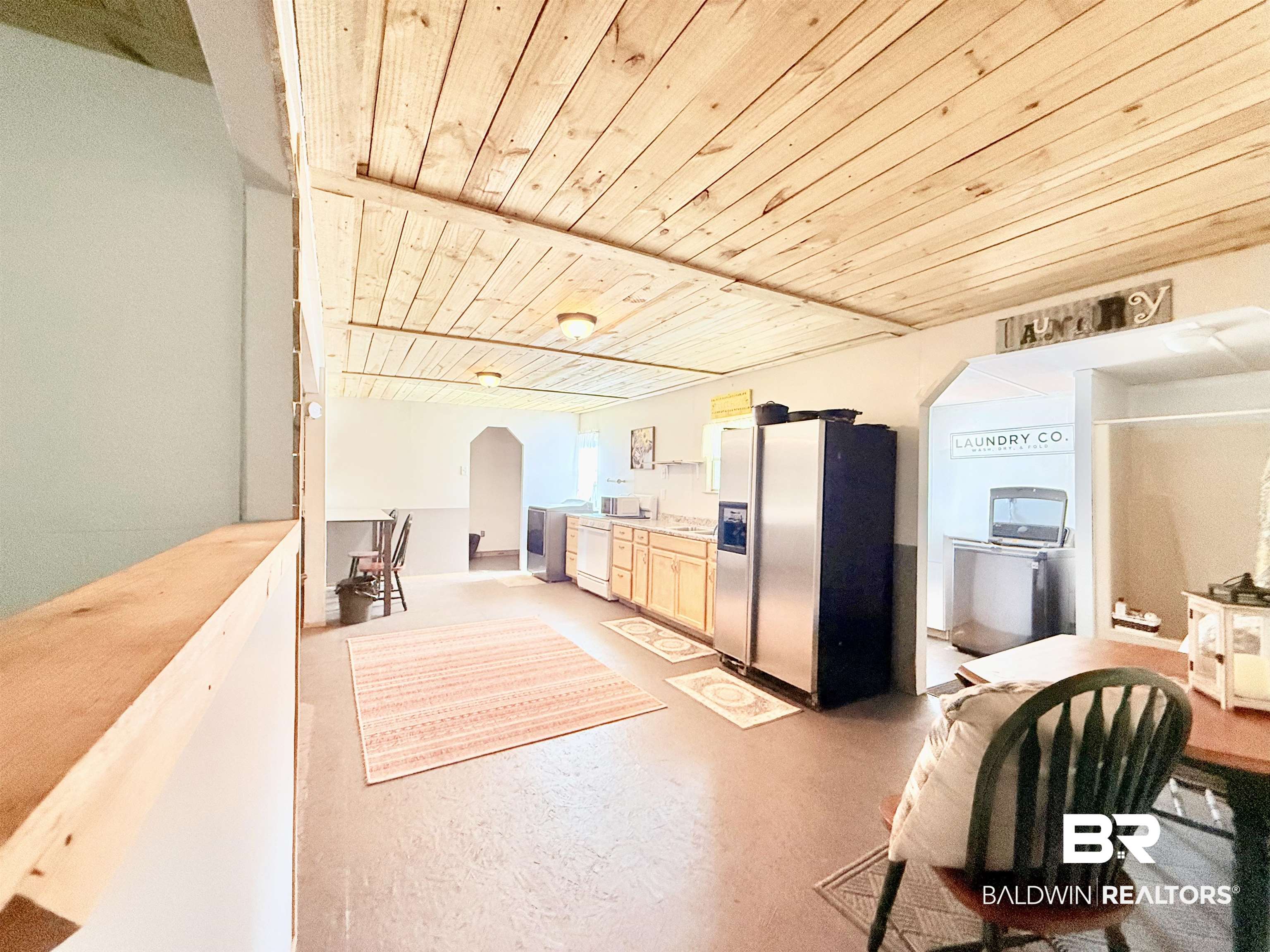 21305 River Road Robertsdale, AL 36567 - Photo 26 of 50 Kitchen featuring stainless steel fridge, wood ceiling, light brown cabinetry, dishwashing machine, and finished concrete flooring