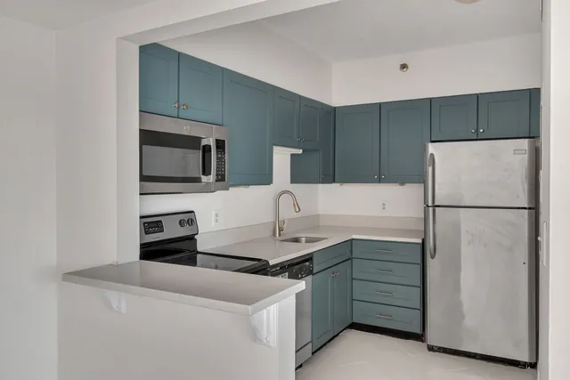 a kitchen with a refrigerator sink and cabinets