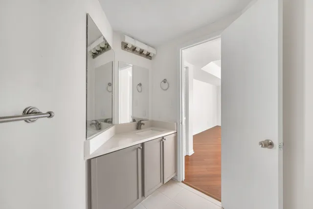 a bathroom with a granite countertop sink a mirror and shower