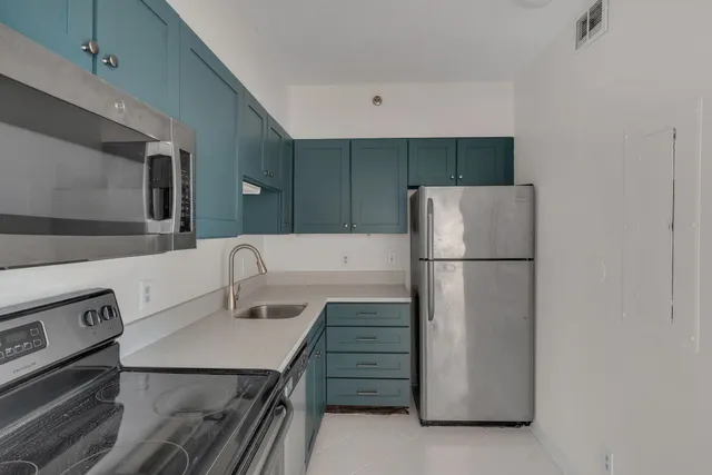 a kitchen with a refrigerator sink stove and cabinets