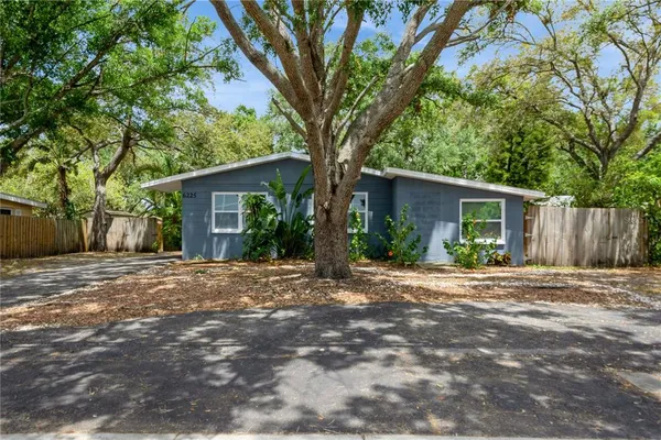 a front view of house with yard and trees around