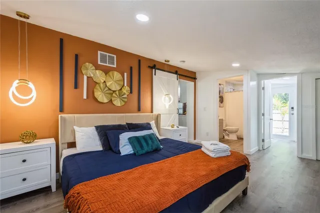 a bedroom with a bed and wooden floor