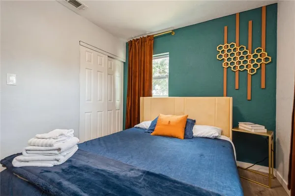 a bedroom with a bed and a potted plant