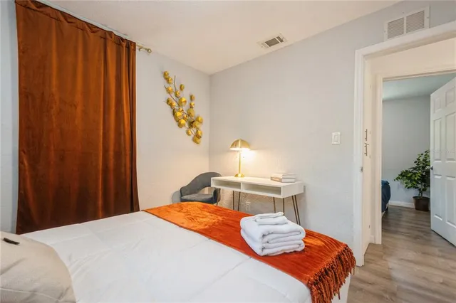 a bedroom with a bed and wooden floor