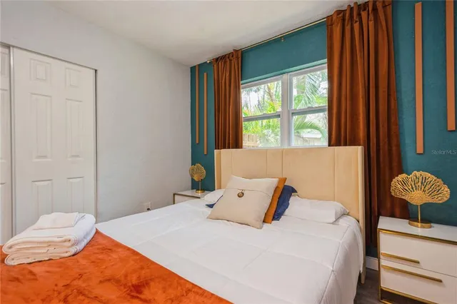 a bedroom with a bed and next to a window