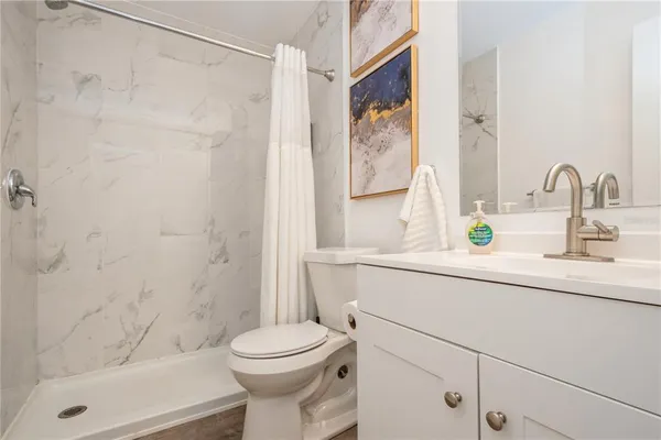 a bathroom with a sink a toilet and shower