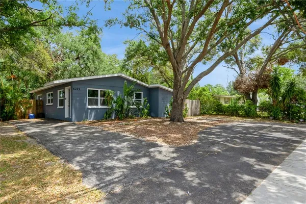 a front view of a house with yard and trees