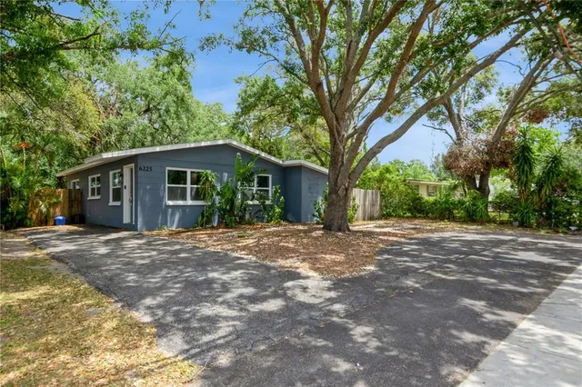 a front view of a house with yard and trees