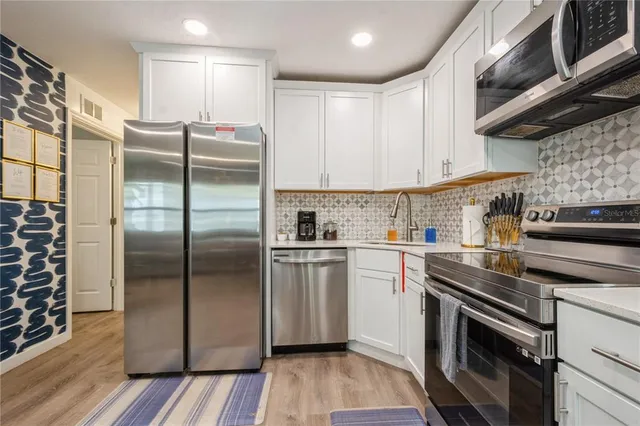 a kitchen with a refrigerator sink and cabinets