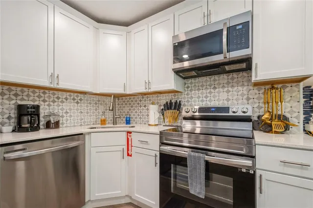 a kitchen with stainless steel appliances a stove sink microwave and cabinets