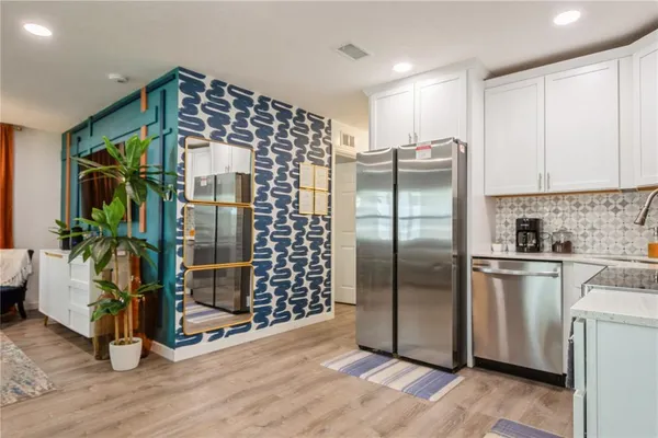 a kitchen with stainless steel appliances granite countertop a refrigerator and a sink