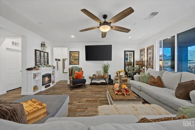 a living room with furniture and a flat screen tv with wooden floor